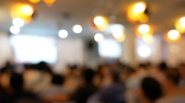 Bulanık arkaplan sunum toplantısı konferans odasında mevcut ekran işinde. İnsanlar konferans salonundaki seminer etkinliğine katılıyorlar. Bokeh ışığı kopya alanı ile bulanık arkaplan