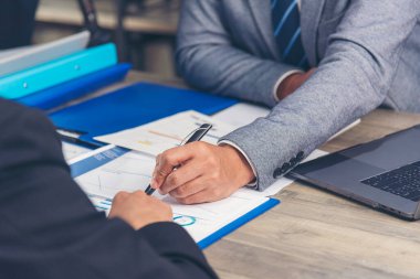 Mutluluk iki iş adamı ofis masasında kendine güvenen ekip toplantısı yapıyor. Dizüstü bilgisayarla çalışan iş ortakları. Asyalı adam iş arkadaşlığı toplantısı.