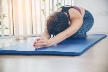 Kadınlar yoga meditasyonu geriliyor, kollar evde meditasyon yapıyor yerde. Yoga yapan genç kadınların mutluluğu Balasana çocuk pozu. Spor giyim sektöründeki sağIıklı kadın rahatlama, rahatlama ve sağlık hizmetlerinde meditasyon yapıyor.