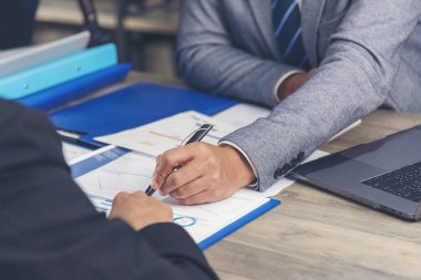 Mutluluk iki iş adamı ofis masasında kendine güvenen ekip toplantısı yapıyor. Dizüstü bilgisayarla çalışan iş ortakları. Asyalı adam iş arkadaşlığı toplantısı.