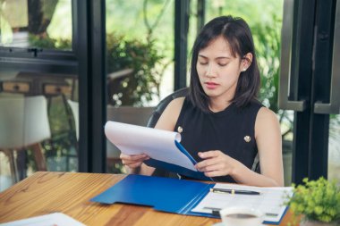 İşletme masasında çalışan bir kadın evdeki dizüstü bilgisayarla çalışıyor. İş kadını finansal iş haritası, grafik, bilgi analizi satış istatistiklerini inceliyor. Kadın ellerini girişimci bürosunun masasına koydu