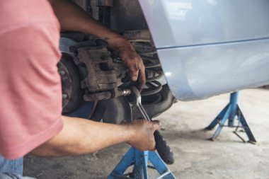 Tamirci araba tamirhanesini kapatırken araba tamircisini de eline aldı. Makineli araç mekanik servisini tamir eden adam elleri. Araç kaputu otomobili kontrol ediyor. Araç bakım mühendisi.