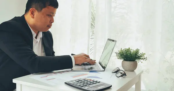 Close up man hands Asian businessman  calculating number, audit planning on business report Asian Business man hands using calculator counting tax financial bill. Tax audit Finacial concept