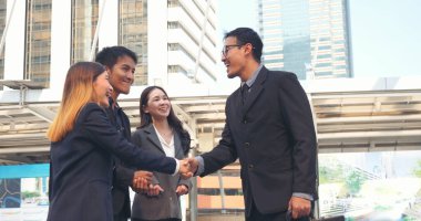 Diversity Business Partner meeting trust in teamwork and partnership businessman, businesswoman talking together in modern city. Asian coworker team meeting with Business People Working Together Team