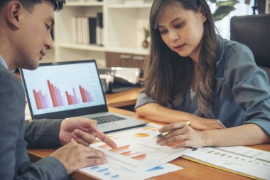 İki iş adamı toplantı ekibi ofis masasındaki mali grafik tablosuna bakmak için dizüstü bilgisayar kullanmayı tartışıyor. Planlama okuyan iki genç işadamı pazarlama bilgilerini analiz ediyor. Ortaklar birlikte çalışıyor.