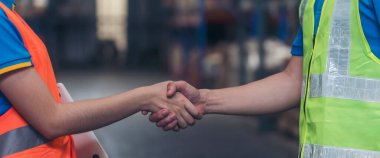 Banner Asyalı Takım Çalışması Depo çalışanı el sıkıştı. Mühendis bey, kadın tokalaşması ortaklığı. İş arkadaşı lojistik depo ekipleri. Takımdaki kişi kopya alanı ile el sıkışıyor