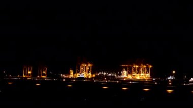 Lojistik nakliye iskelesi, lojistik ihracat terminalinde gece yarısı mühendislik vinç deposunda. Depo yük konteynırı liman limanı lojistik zaman atlaması