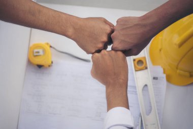 Çok ırklı bir grup ekip çalışması el ele tutuşur Mühendis Foreman yumruk yumruğa çarpışır. Çeşitlilik mühendislerini kapatın. Ortaklar el ele tutuşsun. İş bağlantısı ekibi ortaklığa katıldı