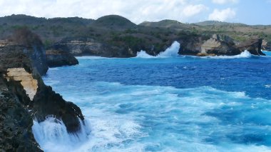 Turkuaz okyanus suyu beyaz dalga açık mavi deniz. Kuş bakışı canavar dalgası kayaya çarpıyor. Yazın açık deniz sahillerinde tropik deniz plajı. Okyanus adası güzel dramatik manzara.