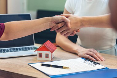Çeşitlilik 'i kapatın bayan ajanlar ofis masasını verin. Ekin Kadınları sigorta ipoteği satışı belgesinde el sıkışma işareti var. İş kadını, emlakçıyla anlaşma imzalayan müşteriyle tokalaşıyor