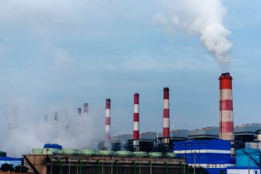 Elektrik santralleri elektrik endüstrisi üretiyor. Elektrik santrali rafinerisi mühendisliği buhar bacası. Linyit elektrik bacaları endüstride kirliliği serbest bırakır mavi gökyüzü