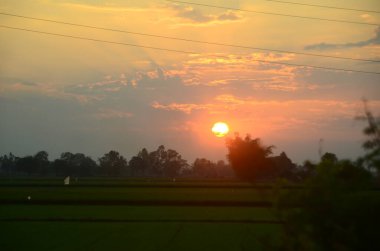 Manzarası dramatik güzel gün batımı gökyüzü. Doğal Günbatımı Karanlık Diyar 'ın gölgesinde. Kırsal kesimde gün batımında, şafakta, gün doğumunda canlı, dramatik bir gökyüzü. Gün batımında manzara Renkli Gökyüzü