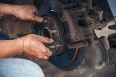 Tamirci araba tamirhanesini kapatırken araba tamircisini de eline aldı. Makineli araç mekanik servisini tamir eden adam elleri. Araç kaputu otomobili kontrol ediyor. Araç bakım mühendisi.