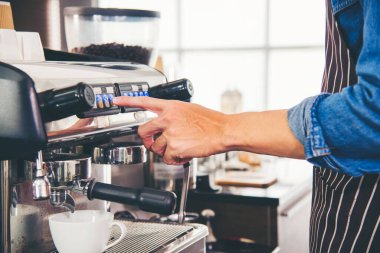 Close up hands coffee barista man make hot cup espresso shot from coffee machine. Cappuccino with milk in italian coffee shop cafe. Close up hands of barista use machine make black drinking hot cup