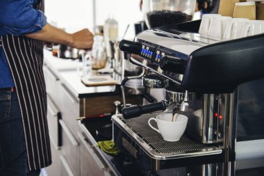 Close up hands coffee barista man make hot cup espresso shot from coffee machine. Cappuccino with milk in italian coffee shop cafe. Close up hands of barista use machine make black drinking hot cup
