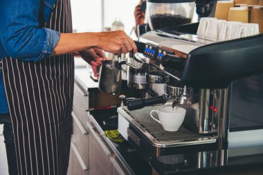 Close up hands coffee barista man make hot cup espresso shot from coffee machine. Cappuccino with milk in italian coffee shop cafe. Close up hands of barista use machine make black drinking hot cup