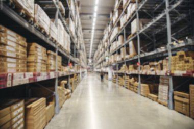 Çelik rafta bulanık arka plan ticari ambalajı. Depoda bir koridor var. Deponun arka planındaki envanter rafında nakliye konteynırı koridoru var. Bulanık malzeme deposu raf karton