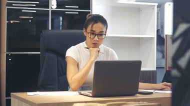 İş kadını elleri, ofis masasındaki defter toplantısına dizüstü bilgisayarla yazı yazar. Asyalı Kadın Eller ofis kâğıdına yazı yazıyor. Dizüstü bilgisayardan takvim kullanıyor. Kalem tutan kadın iş planı.