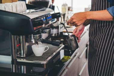 Close up hands coffee barista man make hot cup espresso shot from coffee machine. Cappuccino with milk in italian coffee shop cafe. Close up hands of barista use machine make black drinking hot cup