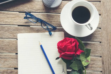 Üst kat ofis masası akıllı tablet kağıt, kahve fincanı gülleri ahşap masada fotokopi alanı ile. Masaüstü not defteri ofisi boş beyaz kağıt kalem kahve fincanı çalışma alanı ahşap zeminini göstermek için