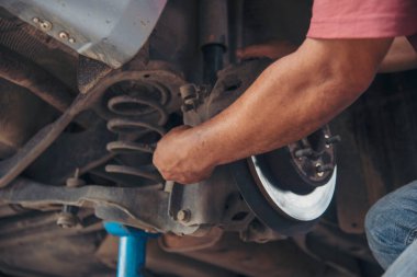 Man ellerini kapat ve şok emici makine araç mekanik servisini onar. Tamirci, araba tamircisini tamir etmek için el yordamıyla lastik değiştirir. Araç bakım mühendisi.