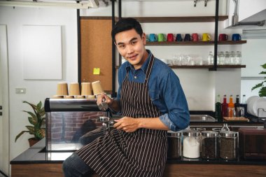 Kahveci Asyalı adam gülümseyen portre küçük işletme özgüvenli işletme yöneticisi profesyonel kahve tezgahı sahibi adama bakın. Barista küçük işletme sahibi