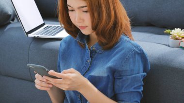 Gülümseyen Asyalı kadın elinde e-ticaret alışverişi internet sitesi Reading Online Article, Blog, vlog ile akıllı telefon tutuyor. Genç kadının elleri telefon teknolojisi yaşam tarzını tutuyor. Akıllı telefon kullanan kadın.