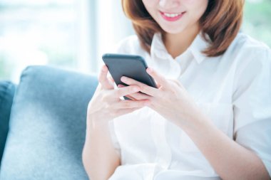 İnternet sitesi Reading Online Article, Blog, vlog ile akıllı telefon tutan Asyalı bir kadın. Genç kadının elleri telefon teknolojisi yaşam tarzını tutuyor. Mutlu Kadın dijital akıllı telefon kullanıyor