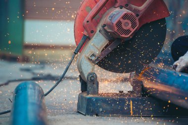 Kaynak makineleri demir metal kıvılcımlar saçıyor. Kızgın alev kaynağı metal işçiliği ateş demir atölyesini kesiyor. Çilingir kaynak makinesi kullanarak metal işlem öğütücüsünü kesiyor. Ağır Mühendis Metal Fabrikası