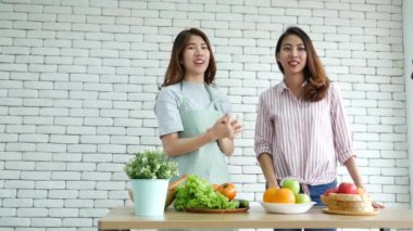 Asyalı vlogger canlı yayında sağlıklı beslenme tarzı hakkında yorum yapıyor. İki genç bayan arkadaş blogcu mutlu bir yaşam tarzı sunuyor. Sebze, meyve, vejetaryen ürünleri nasıl yenir. İki kadın sosyal medya vlog 'undan bahsediyor