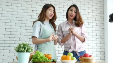 Asyalı vlogger canlı yayında sağlıklı beslenme tarzı hakkında yorum yapıyor. İki genç bayan arkadaş blogcu mutlu bir yaşam tarzı sunuyor. Sebze, meyve, vejetaryen ürünleri nasıl yenir. İki kadın sosyal medya vlog 'undan bahsediyor