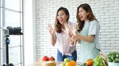İki Asyalı vlogcu birlikte sağlıklı bir yaşam tarzı gözden geçiriyorlar. İki Genç Kadın Arkadaş blogcusu Mutlu Yaşam Biçimi Canlı Yayın. İki kadın sosyal medyadan konuşuyor, merhaba de.