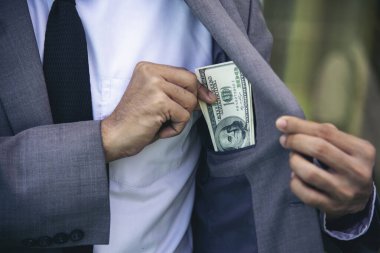 Cüzdanında bir dolarlık banknot var. Finansal ödeme yap. Erkek elleri cüzdanda 100 dolarlık nakit para gösteriyor. İş adamı tasarrufu para banknotu rüşvet yolsuzluk kavramı.