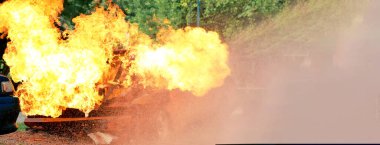 Firefighter Rescue training in fire fighting extinguisher. Firefighter fighting with flame using fire hose chemical water foam spray engine. Fireman wear hard hat, safety suit uniform for protection