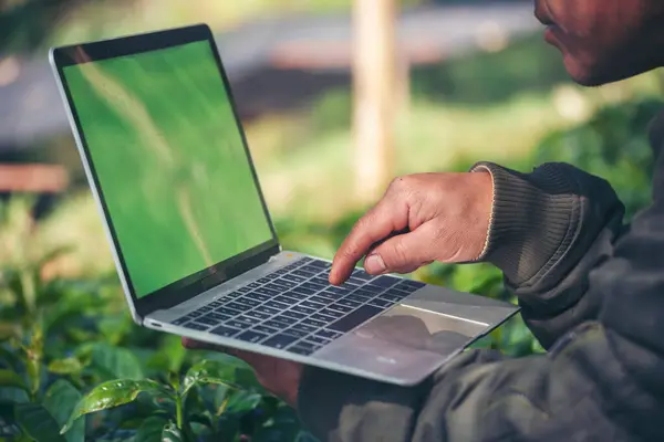 stock image Smart farmer using laptop in eco green farm sustainable quality control. Close up Hand typing laptop computer quality control plant tree. Farmer hands using technology in eco Farmland biotechnology