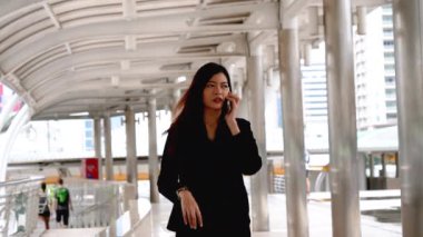 İş kadını internet üzerinden akıllı telefon alışverişi yapıyor, arıyor, internet teknolojisi yaşam tarzı mesaj yolluyor. Şehir caddesinde cep telefonu kullanan Asyalı kadın. Akıllı telefon akıllı, kendine güvenen kadın modern şehir.