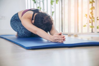 Kadınlar yoga meditasyonu geriliyor, kollar evde meditasyon yapıyor yerde. Yoga yapan genç kadınların mutluluğu Balasana çocuk pozu. Spor giyim sektöründeki sağIıklı kadın rahatlama, rahatlama ve sağlık hizmetlerinde meditasyon yapıyor.