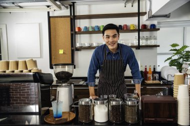 Portre Barista küçük işletme sahibi. Asyalı kahveci adam gülümsüyor. Kameraya bakın. Küçük işletme özgüvenli kişi.