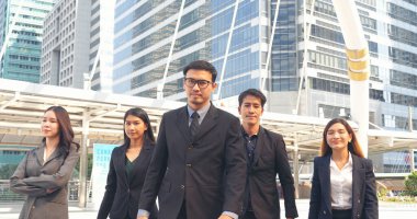 Portrait Group of businesspeople arms crossed smiling look at camera in modern city background. Happy Businessman, businesswoman teams partnership. Business people teams positive teamwork standing.