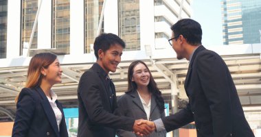 Diversity Business Partner meeting trust in teamwork and partnership businessman, businesswoman talking together in modern city. Asian coworker team meeting with Business People Working Together Team