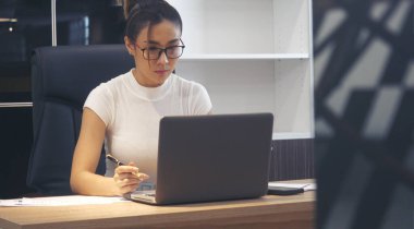 İş kadını elleri, ofis masasındaki defter toplantısına dizüstü bilgisayarla yazı yazar. Asyalı Kadın Eller ofis kâğıdına yazı yazıyor. Dizüstü bilgisayardan takvim kullanıyor. Kalem tutan kadın iş planı.