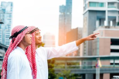 Arap Müslüman erkekler takım çalışanları olarak birlikte konuşuyorlar. Dijital pazarlama Arap grubu modern müslüman BAE şehrine danışmayı tartışıyor. Mutlu Girişimci Asyalı insanlar toplanan gülümseyen takımlar