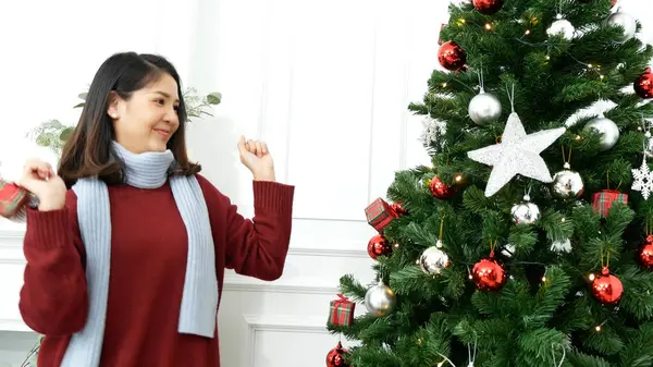 Kadın elleri Noel ağacını süslüyor kırmızı top, takı, kar taneciği. Asyalı kadın dekorasyon balosu balosu Noel ağacı, Noel bayramı kış mevsimsel kutlaması. Gümüş yıldız madalyasını tutan elleri kapatın.