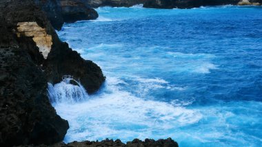 Turkuaz okyanus suyu beyaz dalga açık mavi deniz. Kuş bakışı canavar dalgası kayaya çarpıyor. Yazın açık deniz sahillerinde tropik deniz plajı. Okyanus adası güzel dramatik manzara.