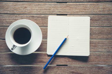 Üst kat ofis masası akıllı tablet kağıt, kahve fincanı gülleri ahşap masada fotokopi alanı ile. Masaüstü not defteri ofisi boş beyaz kağıt kalem kahve fincanı çalışma alanı ahşap zeminini göstermek için