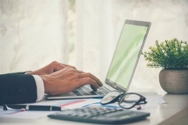 Yakından çalışan işadamları ofis masasında dizüstü bilgisayar finansmanı iş belgelerini kullanarak rapor tablosu okuyorlar. Adam elleri klavye yazın ofis nota kontrol mali grafik grafiği