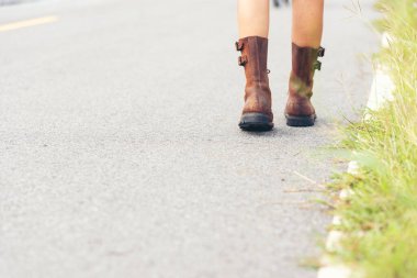 Yolda rahatça yürüyen bir kadın gezgin. Kadınlar yaz parkında yürürken spor ayakkabı giyerler. Orman yolundaki yeşil parkta duran kadınlar var. Genç gezgin yürüyüş yolunda dinleniyor.