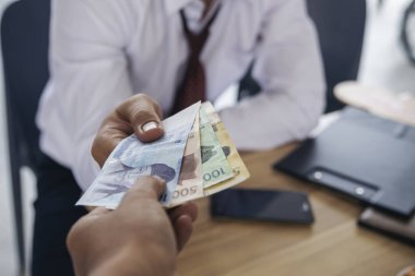 El sıkışın ve rüşvet verin. El ele tutuşan dolar banknotları rüşvet para ekonomisi iş adamları. İş adamları yasadışı yerleşim yerlerini yozlaştırıp rüşvet ödemeye çalışıyorlar. Rüşvet konsepti