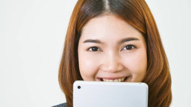 İnternetten dijital tablet alışverişi yapan Asyalı bir kadın arıyor, mesaj yolluyor, internet teknolojisi yaşam tarzında gülümsüyor. Asyalı kadın akıllı tablete dokunuyor mobil uygulama ev ofisini kullanarak ellere odaklanıyor.