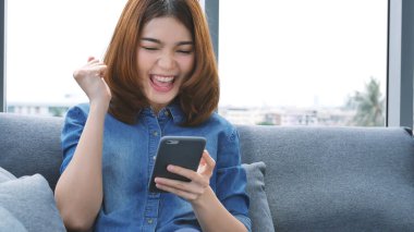 İnternetten dijital tablet alışverişi yapan Asyalı bir kadın arıyor, mesaj yolluyor, internet teknolojisi yaşam tarzında gülümsüyor. Asyalı kadın akıllı tablete dokunuyor mobil uygulama ev ofisini kullanarak ellere odaklanıyor.